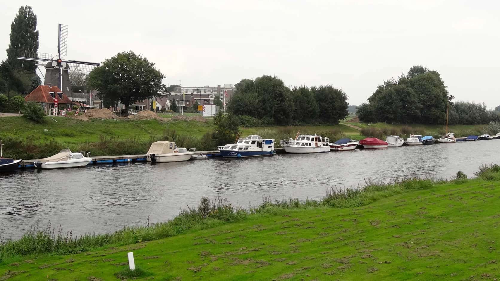 De Vecht bij Ommen met groene oevers, boten en een molen langs het water.